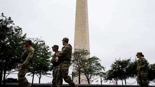 National Guard troops in Washington, DC, begin carrying weapons