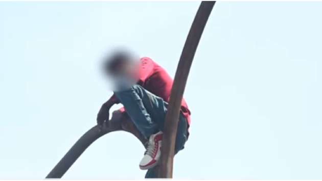 Young man rescued after climbing lamp post in Fort