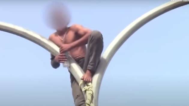 Man rescued after climbing utility post demanding wife’s return