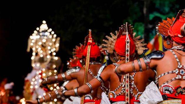 Traditional Kandyan dancers and an illuminated ceremonial elephant during the Kandy Esala Perahera