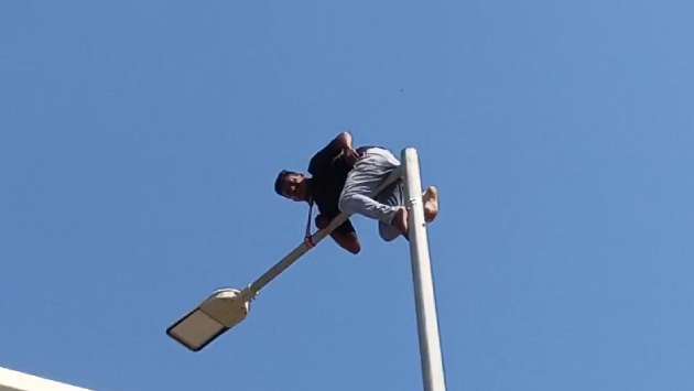 Protestor climbs electric pole at Galle Face alleging police injustice