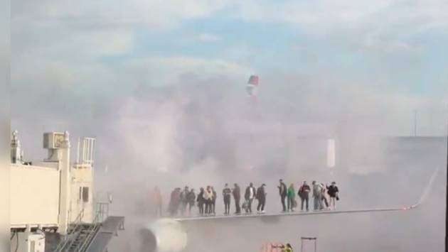 Passengers evacuate onto wing of burning American Airlines jet