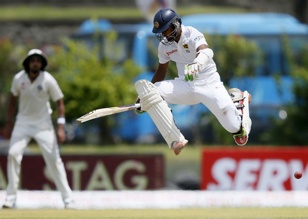 Chandimal jumps over the ball