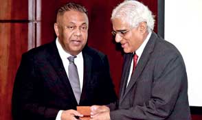 Central Bank Governor Indrajit Coomaraswamy presents Finance Minister Mangala Samaraweera the commem